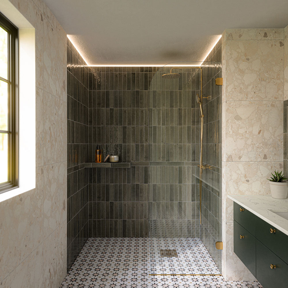 Contemporary walk-in shower featuring Izmir Sage Green gloss brick wall tiles, Agraba Natural Moroccan style patterned floor tiles, large terrazzo effect wall tiles, brushed brass shower fittings and a floating sage green vanity for a warm, modern bathroom.