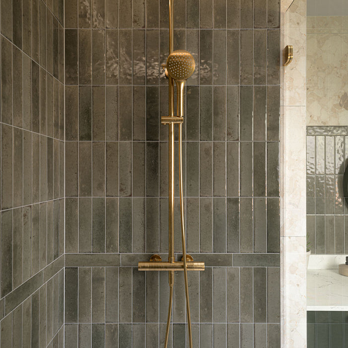 Contemporary walk-in shower featuring Izmir Sage Green gloss brick wall tiles, Agraba Natural Moroccan style patterned floor tiles, large terrazzo effect wall tiles, brushed brass shower fittings and a floating sage green vanity for a warm, modern bathroom.