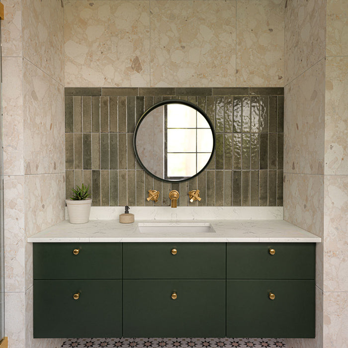 Contemporary walk-in shower featuring Izmir Sage Green gloss brick wall tiles, Agraba Natural Moroccan style patterned floor tiles, large terrazzo effect wall tiles, brushed brass shower fittings and a floating sage green vanity for a warm, modern bathroom.