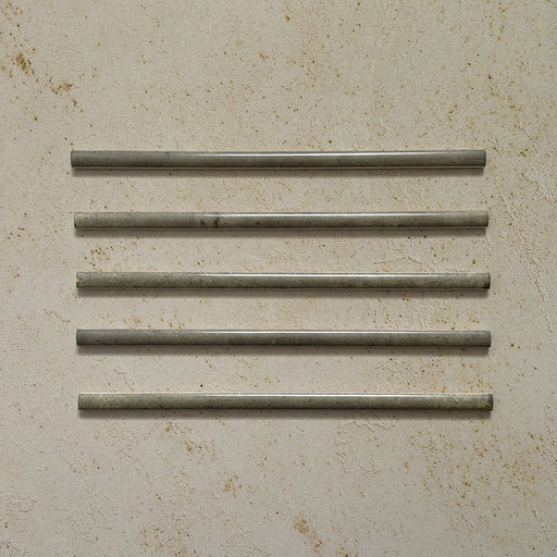 Five Izmir Sage Green Gloss Pencil Bullnose Border Tiles 1.2x30cm displayed on a textured beige background, showing subtle shade variation, smooth rounded edges, and a glossy handcrafted effect finish.