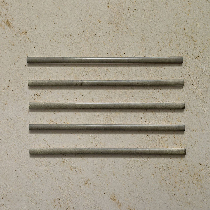Five Izmir Sage Green Gloss Pencil Bullnose Border Tiles 1.2x30cm displayed on a textured beige background, showing subtle shade variation, smooth rounded edges, and a glossy handcrafted effect finish.