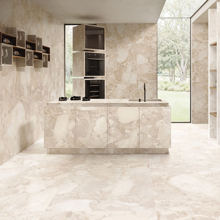 Contemporary kitchen featuring Jeddah Avorio Sassi Terrazzo Stone 60x120cm stone-effect wall and floor tiles, showcasing warm ivory and beige tones with natural stone-inspired detailing, paired with a matching waterfall island, integrated cabinetry and floor-to-ceiling glazing.