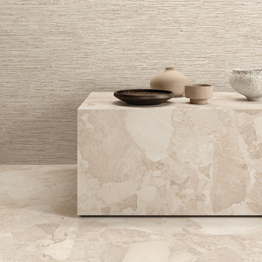 Interior featuring Jeddah Avorio Sassi Terrazzo Stone 60x60cm stone-effect wall and floor tiles, showcasing warm ivory and beige tones with natural stone-inspired detailing, styled with matching tiled cabinetry and light wood shelving for a contemporary finish.