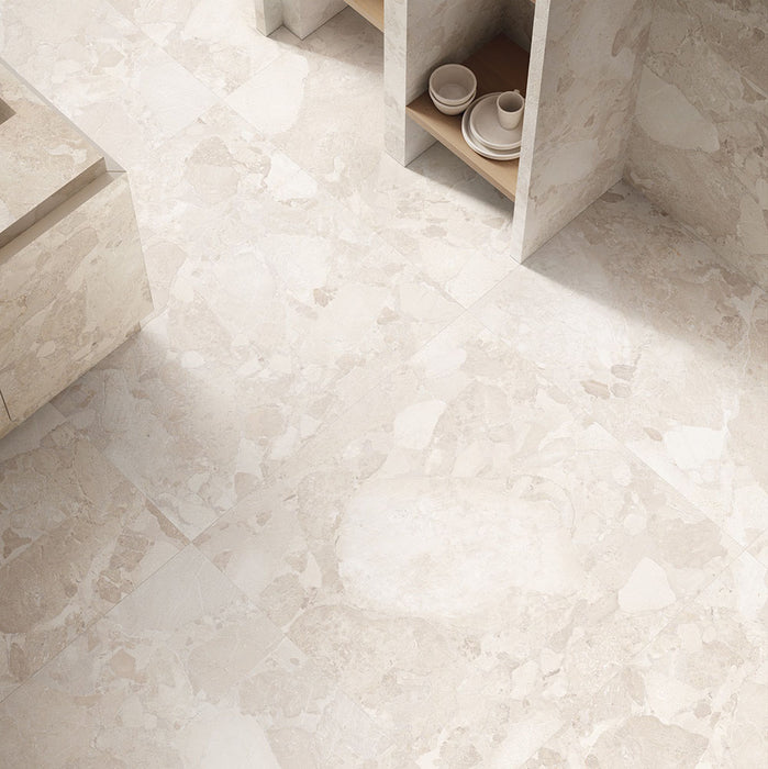 Interior featuring Jeddah Avorio Sassi Terrazzo Stone 60x60cm stone-effect wall and floor tiles, showcasing warm ivory and beige tones with natural stone-inspired detailing, styled with matching tiled cabinetry and light wood shelving for a contemporary finish.