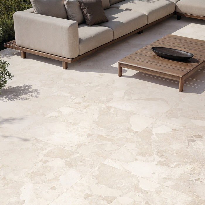 Contemporary outdoor patio featuring Jeddah Avorio Terrazzo 20mm 100x100cm outdoor stone-effect porcelain tile slabs, showcasing warm ivory and beige tones, paired with minimalist lounge seating, timber furniture and landscaped gardens.