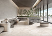 Contemporary lounge featuring Jeddah Blanco Sassi Terrazzo Stone 60x120cm stone-effect floor tiles, showcasing soft cream and beige tones with natural stone-inspired detailing, paired with minimalist seating, indoor planting and floor-to-ceiling glazing.