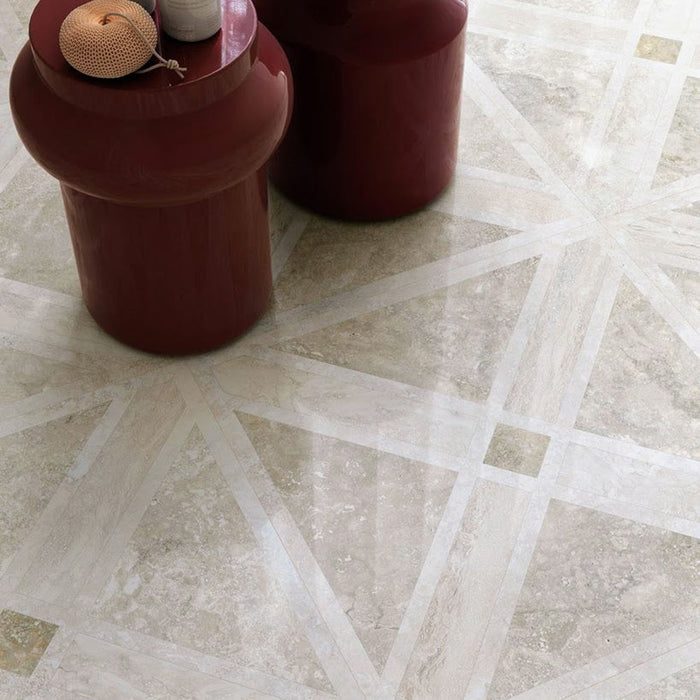 Close-up of Jesi Travertine Decor 60x60cm travertine effect floor tiles, showcasing a geometric linear pattern in soft cream and beige tones, paired with burgundy side tables for a refined, contemporary interior.