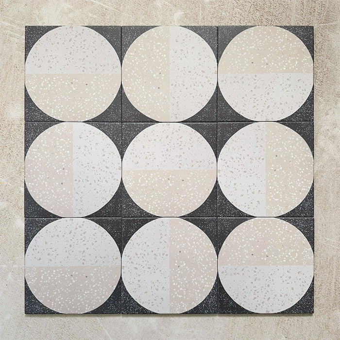 Kasuf Night 20x20cm terrazzo-style decor tiles featuring a bold monochrome circular pattern with speckled terrazzo detailing, ideal for creating statement floors and contemporary geometric interiors.