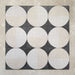 Kasuf Night 20x20cm terrazzo-style decor tiles featuring a bold monochrome circular pattern with speckled terrazzo detailing, ideal for creating statement floors and contemporary geometric interiors.