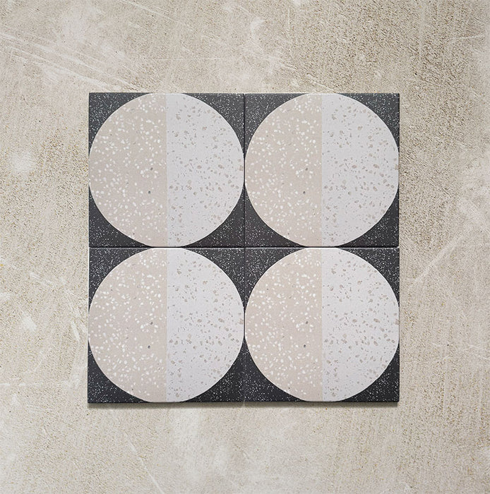 Kasuf Night 20x20cm terrazzo-style decor tiles featuring a bold monochrome circular pattern with speckled terrazzo detailing, ideal for creating statement floors and contemporary geometric interiors.