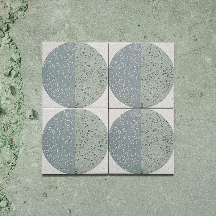 Kasuf Verde 20x20cm terrazzo-style decor tiles featuring a soft sage green and pale blue circular pattern with speckled terrazzo detailing, perfect for creating calming geometric floors and contemporary statement interiors.
