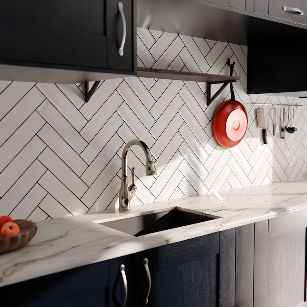 Durban gloss white handmade-effect tiles in a herringbone layout, styled as a kitchen splashback with dark cabinetry and marble worktops.