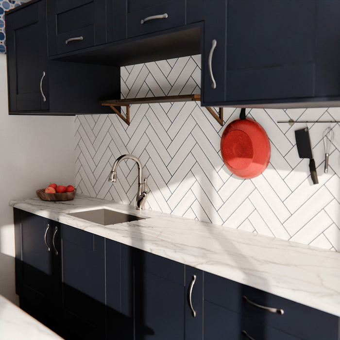 Durban gloss white handmade-effect tiles in a herringbone layout, styled as a kitchen splashback with dark cabinetry and marble worktops.
