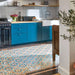 Kitchen interior featuring Europa Helsinki 20x20cm Victorian Moroccan style floor tiles in teal, terracotta and cream tones, installed with a decorative border and styled with teal cabinets, wooden worktops and a black range cooker.