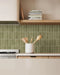 Kitchen featuring Atlas Verde Mini Brick 5x15cm matt wall tiles, installed in a vertical layout, showcasing rich green tones with a subtle textured finish, paired with wood cabinetry and a warm, contemporary interior setting.