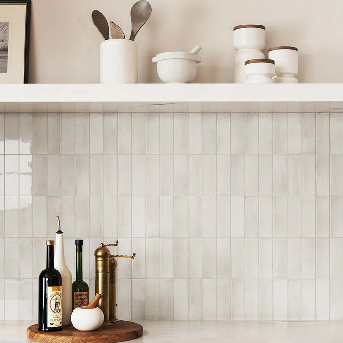 Kitchen setting featuring Atlas White Mini Brick 5x15cm gloss wall tiles, arranged in a horizontal brick pattern to create a clean, structured backdrop. The soft white tones and subtle tonal variation bring a sense of depth, while the gloss finish reflects light across the surface, enhancing brightness throughout the space.