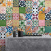 Kitchen setting featuring Fihrdos Mini Patchwork Moroccan-style 15x15cm patterned porcelain wall tiles, showcasing a vibrant mix of colourful geometric designs behind a modern stone island.