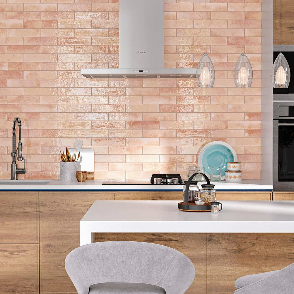 Izmir Brick Tusk Rose Gloss 6x25cm — shown in a contemporary kitchen setting. These blush-toned brick tiles feature a glossy handcrafted finish that reflects light beautifully, adding warmth and character to modern and rustic spaces alike. Perfect for creating an inviting statement splashback.