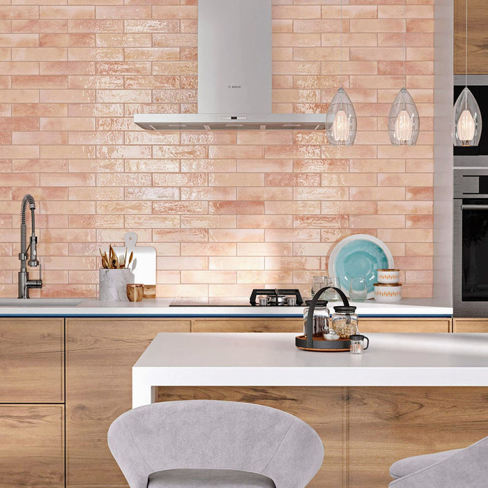 Izmir Brick Tusk Rose Gloss 6x25cm — shown in a contemporary kitchen setting. These blush-toned brick tiles feature a glossy handcrafted finish that reflects light beautifully, adding warmth and character to modern and rustic spaces alike. Perfect for creating an inviting statement splashback.
