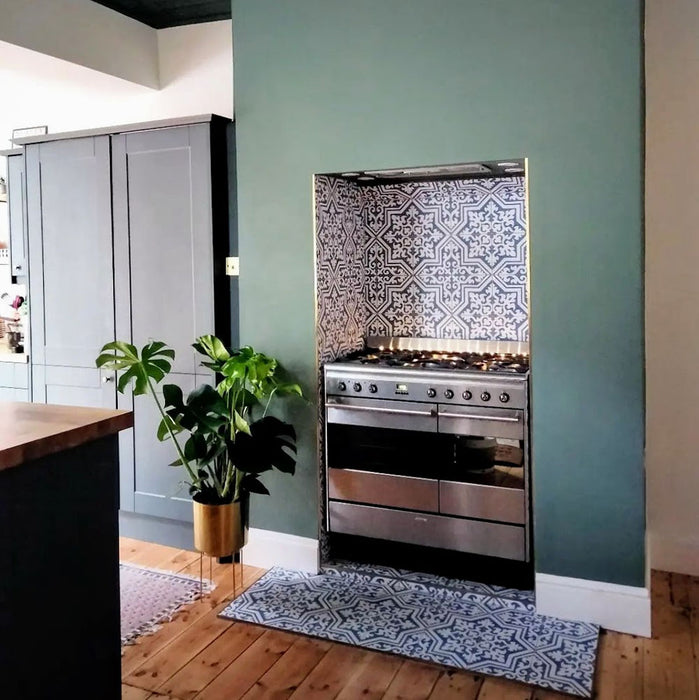 Kitchen interior featuring Europa Trondheim Blue 20x20cm Victorian Moroccan style tiles in blue and white tones, installed as a decorative splashback and hearth area behind a stainless steel range cooker.