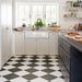 Kitchen featuring Chessboard Black 25×25cm Victorian-style porcelain floor tiles laid in a diagonal black-and-white chequerboard pattern, styled with light wood cabinetry, a farmhouse sink, open shelving, and a dark island for a modern country look.