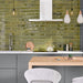 Modern kitchen featuring Izmir Brick Daisy Green Gloss 6x25cm ceramic wall tiles, styled with grey cabinetry, white marble-effect countertops, wooden accents, and contemporary pendant lighting.