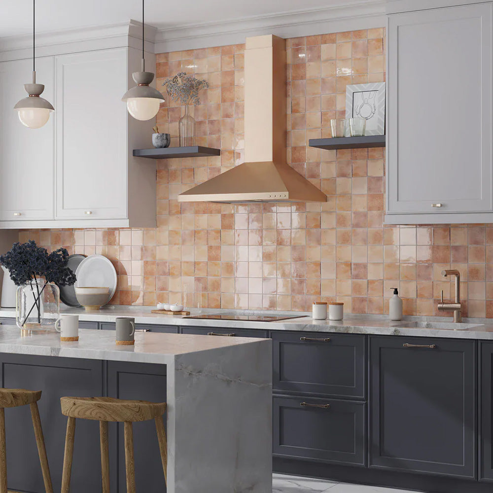 Kitchen featuring Beijing Rose Pink Square 10x10cm Moroccan-style ceramic wall tiles, styled with navy cabinetry, marble countertops and a brushed gold extractor hood.