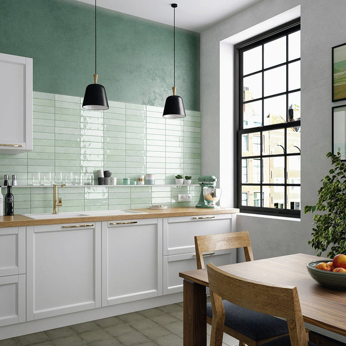 Madison Mint Green Brick Wall Tiles 6x24.6cm — kitchen setting featuring soft green hues and a glossy handmade finish. These refreshing tiles pair beautifully with natural wood and brass accents, adding a light and airy feel to modern kitchens.