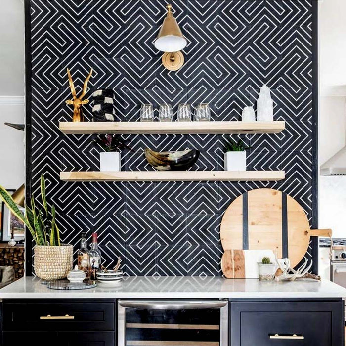 Alhambra Zig Zag Black 20x20cm Moroccan tiles used as a bold kitchen feature wall with open wooden shelves and gold accents, showcasing the striking black and white geometric chevron pattern.