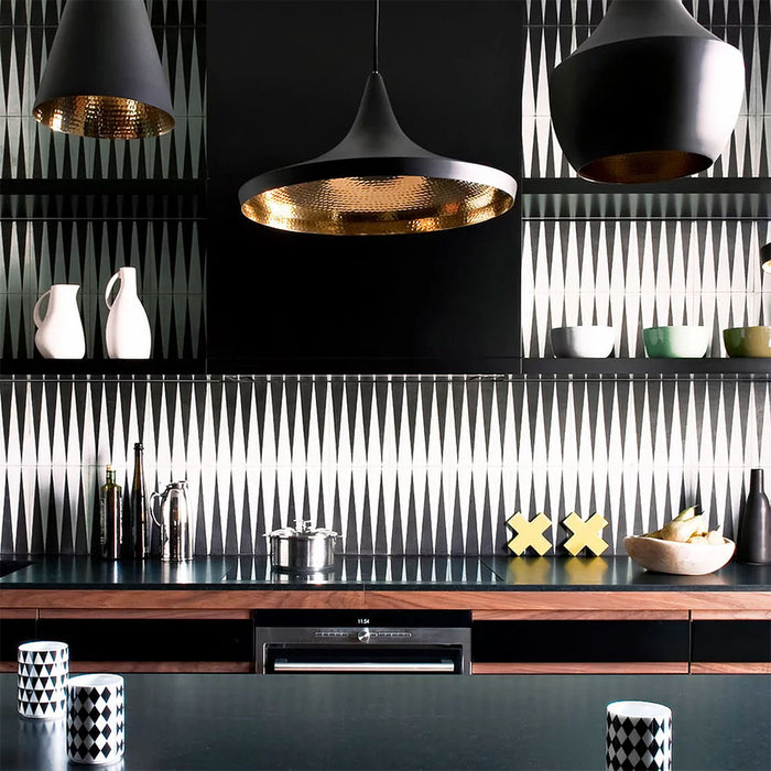 Alhambra Tavla 20x20cm Moroccan tiles used as a kitchen backsplash, showcasing a striking black and white triangular geometric pattern paired with dark cabinetry, gold pendant lights, and modern decor for a bold, contemporary look.