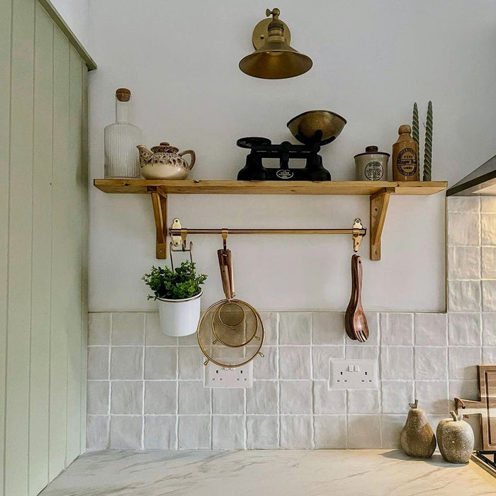 Kitchen interior featuring Zellij Oyster 10x10cm Moroccan-style square tiles in soft off-white tones, installed as a splashback, styled with warm wood shelving, brass accents, and neutral accessories for a calm, timeless look.