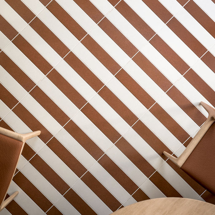 Kutani Cotto 9.1cm x 37.5cm porcelain tiles, paired with Kutani Vanilla in a bold striped layout that highlights the warm terracotta tone and clean linear format.