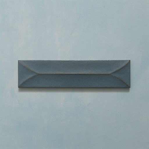 Single Kutani Decor Laguna Blue 9.1cm x 37.5cm porcelain wall tile, featuring a deep blue-grey finish with raised geometric detailing, subtle tonal variation and softly irregular edges.