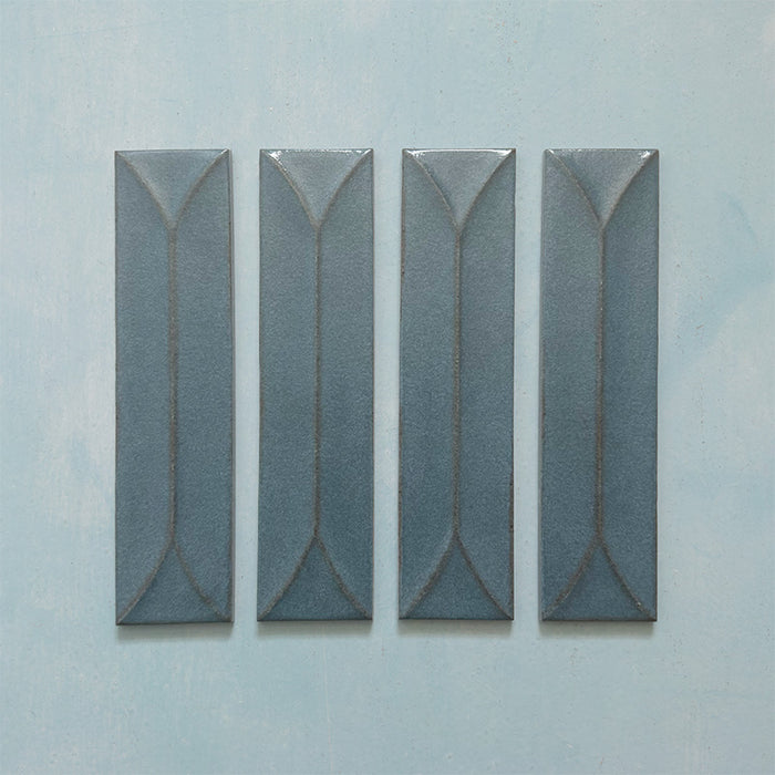 Kutani Decor Laguna Blue 9.1cm x 37.5cm porcelain wall tile, featuring a deep blue-grey finish with raised geometric detailing, subtle tonal variation and softly irregular edges.