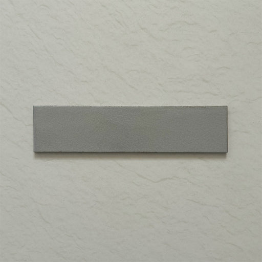Single Kutani Lichen Green 9.1cm x 37.5cm porcelain wall and floor tile, featuring a muted grey-green finish with subtle tonal variation and softly irregular edges.