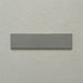 Single Kutani Lichen Green 9.1cm x 37.5cm porcelain wall and floor tile, featuring a muted grey-green finish with subtle tonal variation and softly irregular edges.