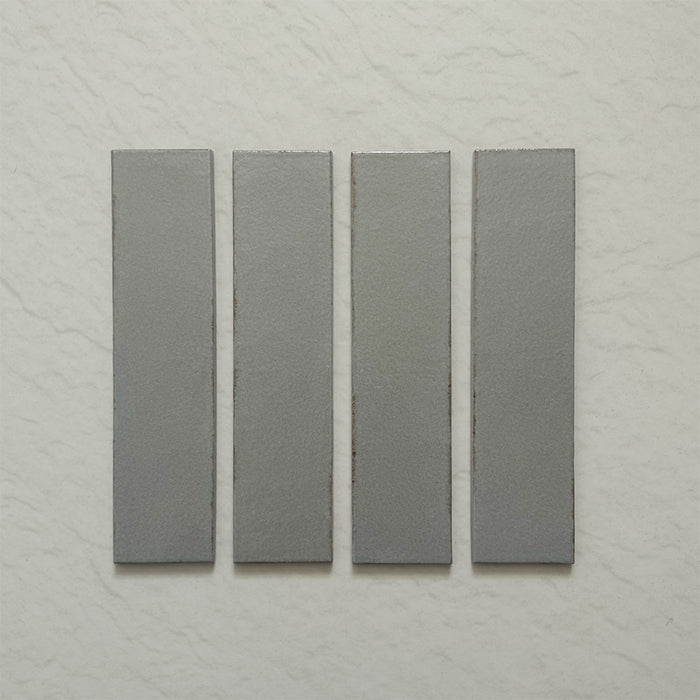 Kutani Lichen Green 9.1cm x 37.5cm porcelain wall and floor tile, featuring a muted grey-green finish with subtle tonal variation and softly irregular edges.