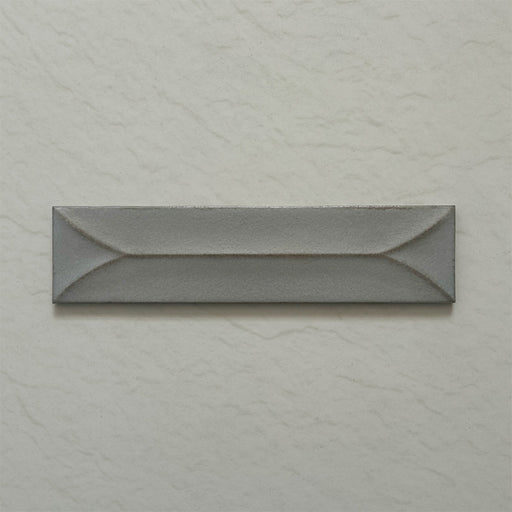 Single Kutani Decor Lichen Green 9.1cm x 37.5cm porcelain wall tile, featuring a muted grey-green finish with raised geometric detailing, subtle tonal variation and softly irregular edges.