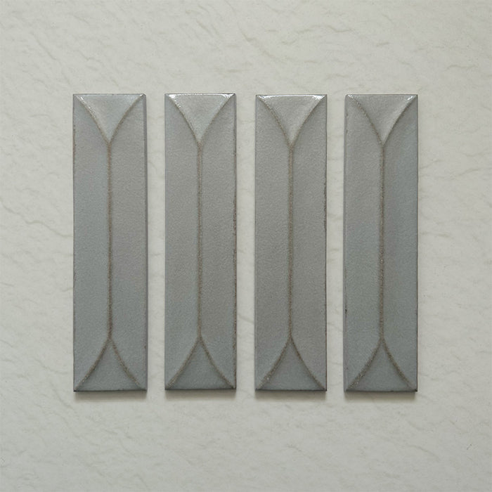 Kutani Decor Lichen Green 9.1cm x 37.5cm porcelain wall tile, featuring a muted grey-green finish with raised geometric detailing, subtle tonal variation and softly irregular edges.