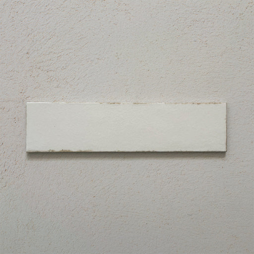 Single Kutani Vanilla 9.1cm x 37.5cm porcelain wall and floor tile, featuring a soft off-white finish with subtle tonal variation and gently irregular edges for a handcrafted look.