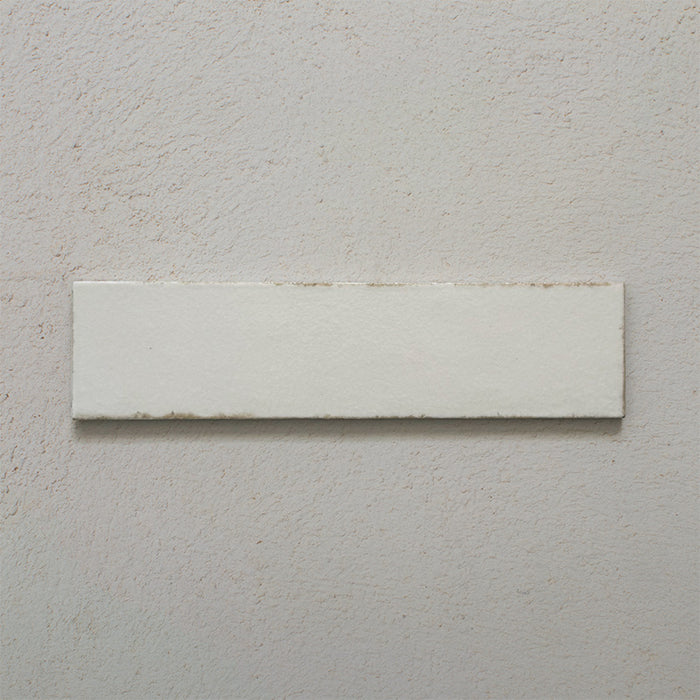 Single Kutani Vanilla 9.1cm x 37.5cm porcelain wall and floor tile, featuring a soft off-white finish with subtle tonal variation and gently irregular edges for a handcrafted look.