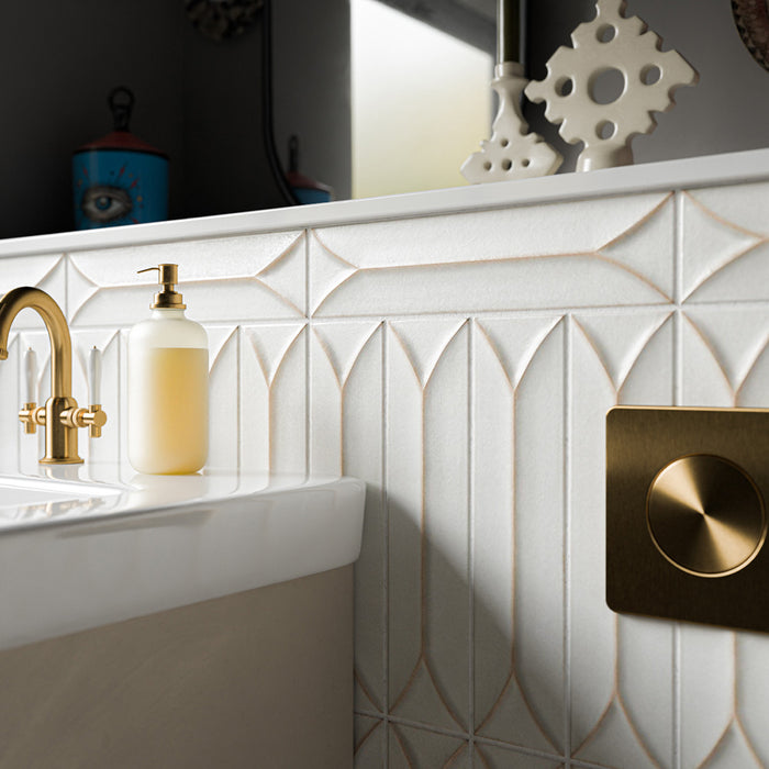 Kutani Decor Vanilla 9.1cm x 37.5cm porcelain wall tiles, showcasing a sculpted geometric surface with subtle warm-toned detailing, paired with brushed brass fittings and crisp white bathroom finishes.