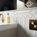 Kutani Decor Vanilla 9.1cm x 37.5cm porcelain wall tiles, showcasing a sculpted geometric surface with subtle warm-toned detailing, paired with brushed brass fittings and crisp white bathroom finishes.