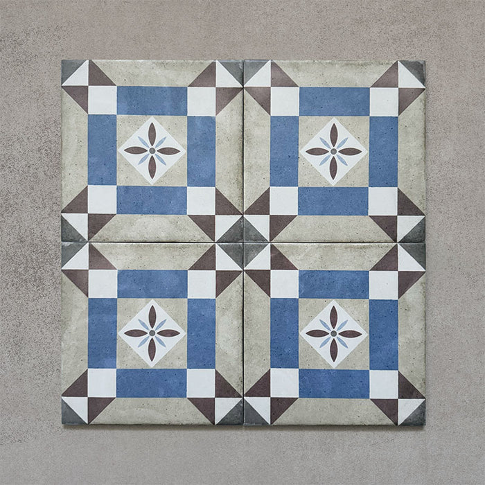 Four-tile layout of Carnaby Lane Victorian-style 20x20cm porcelain wall and floor tiles, highlighting the blue and taupe geometric border design with a central floral motif on an aged neutral background.
