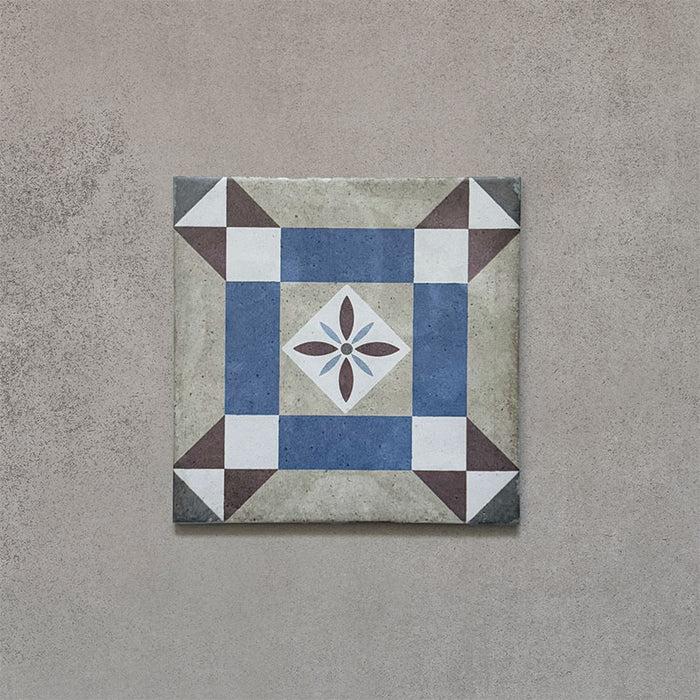 Single tile from the Carnaby Lane Victorian-style collection, 20x20cm porcelain wall and floor tile, featuring a blue and taupe geometric border with a central floral motif on an aged neutral background.