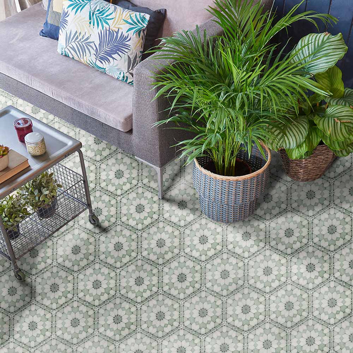 Maroush Green 18.7x21.6cm Moroccan tiles used in a living room setting, featuring intricate geometric floral patterns in soft green and white tones beneath a grey sofa and lush potted plants for a fresh, elegant look.