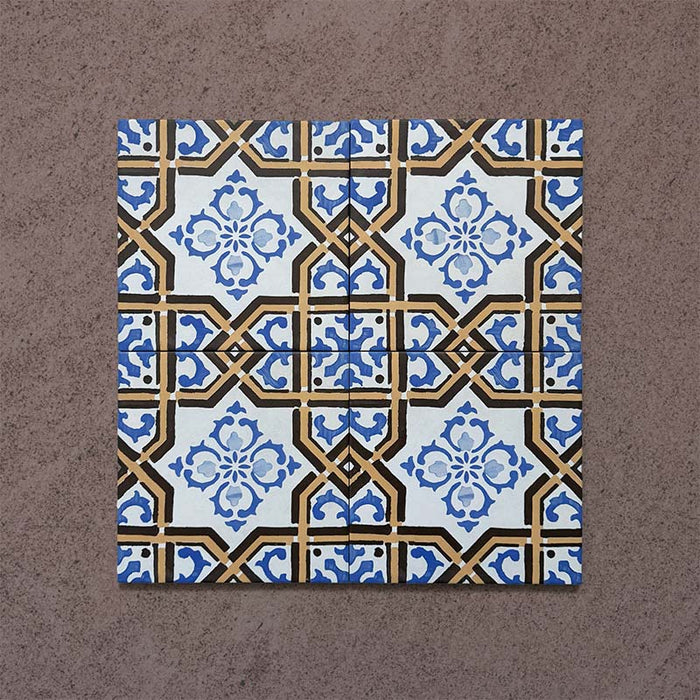 Four-tile layout of Carnaby Maestro Victorian-style 20x20cm porcelain tiles, displaying the repeating blue floral motif with mustard and black geometric framing on an aged white background.