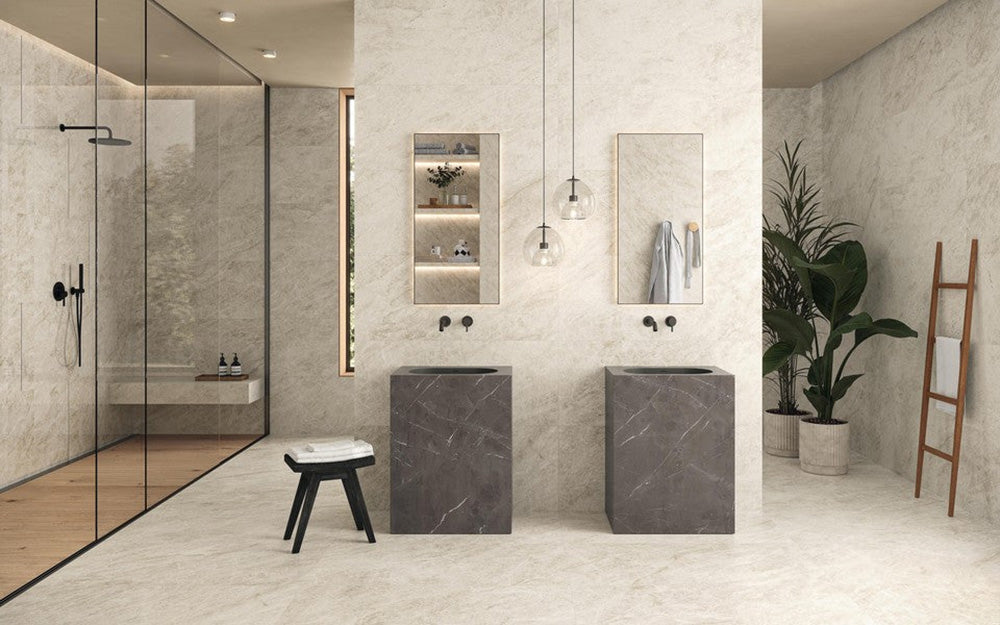 Bathroom interior featuring Grand Mahal Matt Marble effect 60 × 120cm porcelain wall and floor tiles, showcasing a soft ivory base with subtle beige and gold veining, paired with double stone-effect basins, black fittings, and minimalist styling for a calm, contemporary finish.
