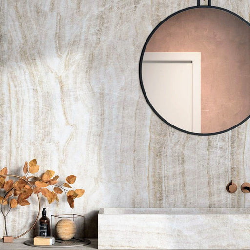 Bathroom interior featuring Grand Mahal Polished Marble effect 60 × 120cm porcelain wall tiles, styled with a floating vanity, round mirror, warm brass fittings, and autumnal decor highlighting soft beige tones and natural veining.
