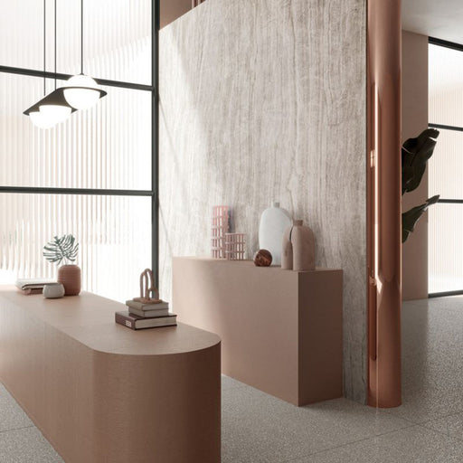Interior space featuring Grand Mahal Polished Marble effect 60 × 60cm porcelain wall and floor tiles, styled with curved blush-toned furniture, sculptural decor, and soft natural light enhancing delicate veining and texture.